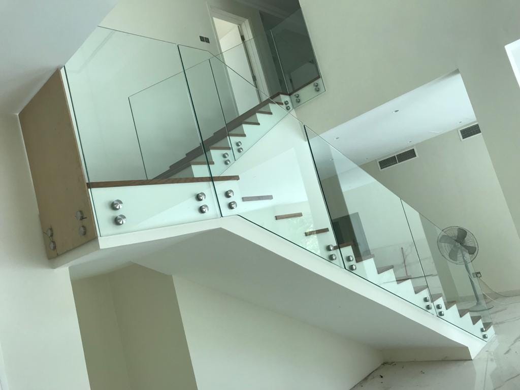 Cantilevered glass railing detail with stainless handrail